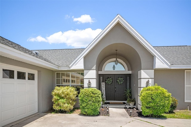 8712 Ashbury Dr, Hudson, FL 34667 - property entrance featuring roof with shingles, stucco siding, and a garage