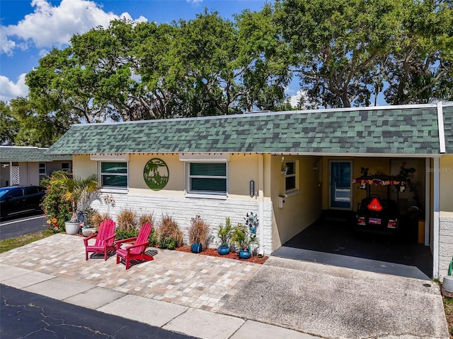 149 Sky Loch Dr E, Dunedin, FL 34698 - single story home with driveway, a shingled roof, and stucco siding