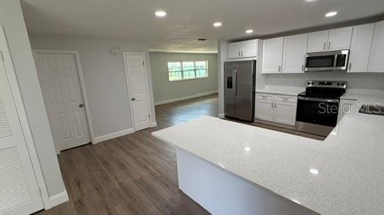 3188 Lake Saxon Dr, Land O Lakes, FL 34639 - kitchen with dark wood-style flooring, light countertops, stainless steel appliances, baseboards, and recessed lighting