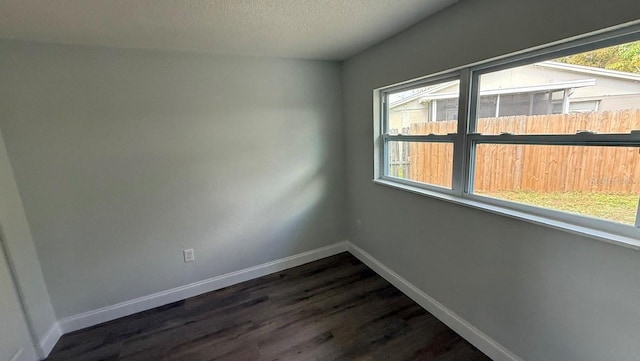 3188 Lake Saxon Dr, Land O Lakes, FL 34639 - unfurnished room featuring dark wood-style flooring, baseboards, and a textured ceiling
