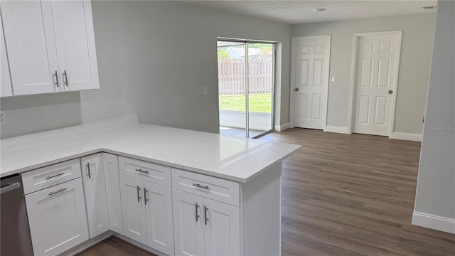 3188 Lake Saxon Dr, Land O Lakes, FL 34639 - kitchen featuring stainless steel dishwasher, baseboards, white cabinets, a peninsula, and dark wood-style floors