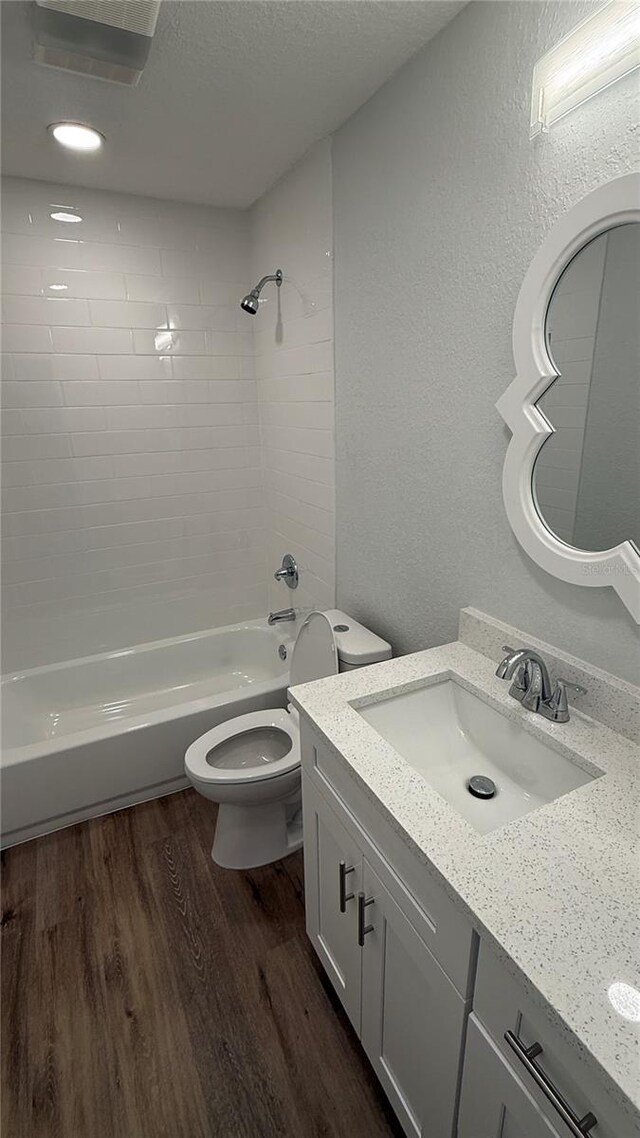 3188 Lake Saxon Dr, Land O Lakes, FL 34639 - bathroom featuring shower / bathing tub combination, wood finished floors, vanity, toilet, and a textured wall