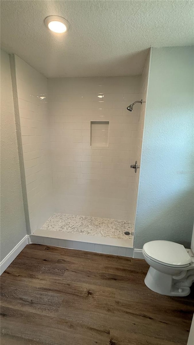 3188 Lake Saxon Dr, Land O Lakes, FL 34639 - bathroom with a stall shower, a textured ceiling, wood finished floors, and toilet