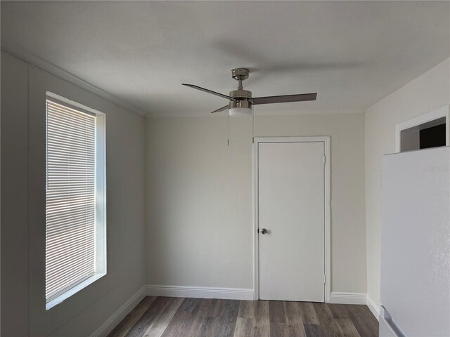empty room featuring baseboards, a ceiling fan, and wood finished floors
