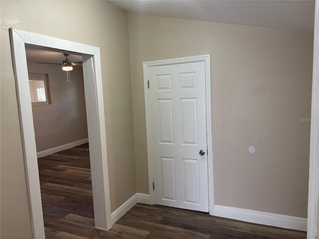 hallway with baseboards, lofted ceiling, and dark wood-type flooring