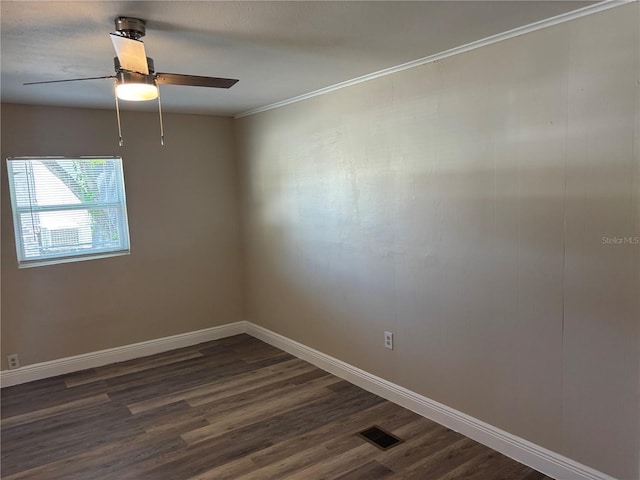 spare room with a ceiling fan, visible vents, crown molding, dark wood finished floors, and baseboards