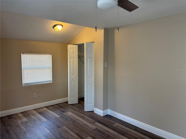 unfurnished bedroom featuring vaulted ceiling, baseboards, a closet, and dark wood finished floors