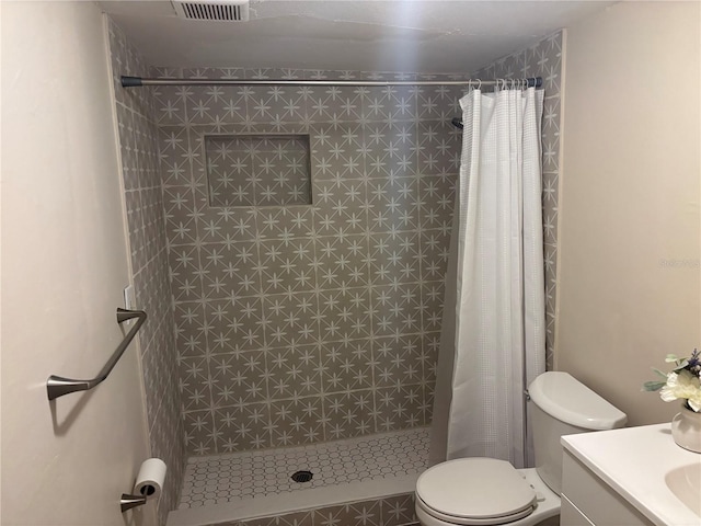 bathroom featuring visible vents, a stall shower, toilet, and vanity