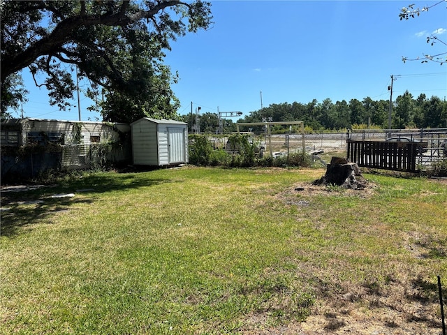 view of yard with fence, an outbuilding, and a shed