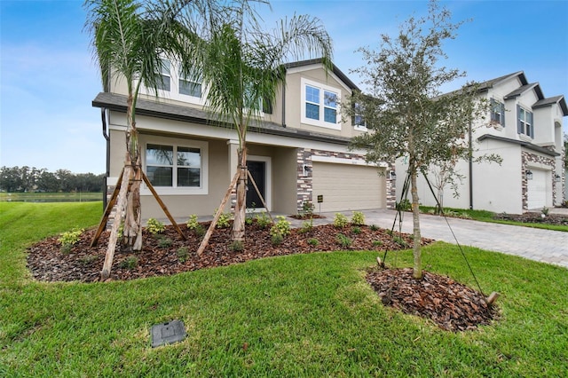 view of front of home with a garage, stucco siding, a front yard, and concrete driveway
