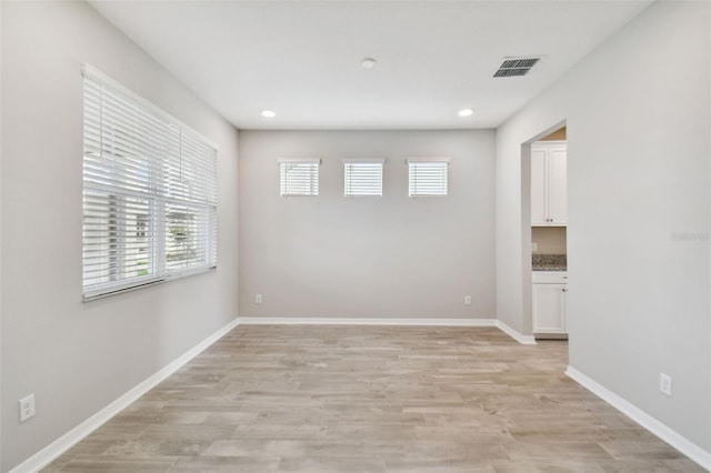 unfurnished room with baseboards, recessed lighting, light wood-style flooring, and visible vents