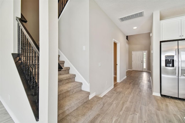 interior space featuring baseboards, recessed lighting, wood finished floors, and visible vents