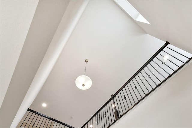 stairs featuring a skylight and a towering ceiling