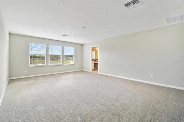 empty room with visible vents, carpet flooring, and baseboards