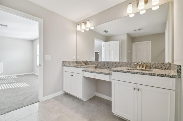 bathroom with a sink, baseboards, double vanity, and visible vents