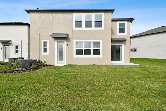 rear view of property featuring central AC unit, stucco siding, and a yard