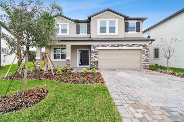 38190 Shale Stone Ct, Zephyrhills, FL 33540 - craftsman-style home with stucco siding, decorative driveway, an attached garage, stone siding, and a front lawn