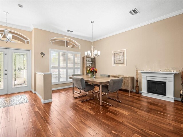 dining area with visible vents, ornamental molding, wood finished floors, and a notable chandelier