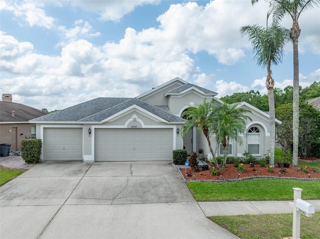 29542 Forest Glen Dr, Wesley Chapel, FL 33543 - ranch-style house with a front lawn, roof with shingles, stucco siding, concrete driveway, and an attached garage
