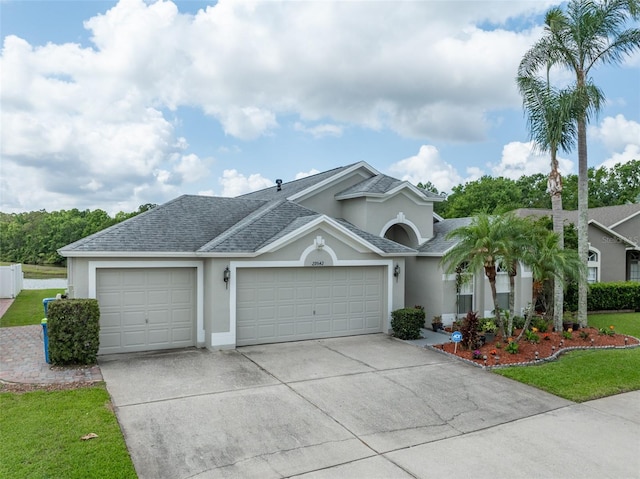 29542 Forest Glen Dr, Wesley Chapel, FL 33543 - ranch-style home with roof with shingles, stucco siding, an attached garage, and driveway