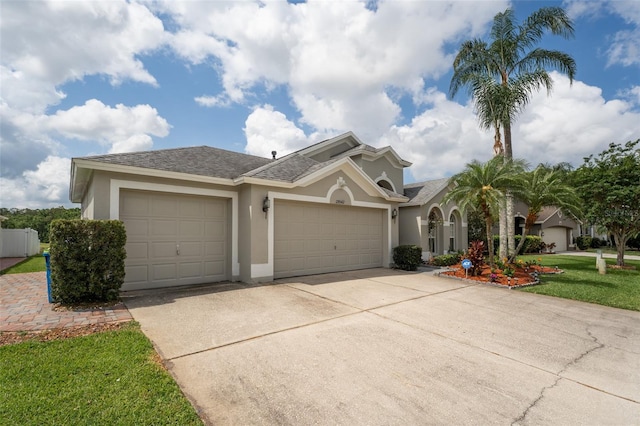 29542 Forest Glen Dr, Wesley Chapel, FL 33543 - mediterranean / spanish-style home with a shingled roof, a garage, stucco siding, a front yard, and driveway