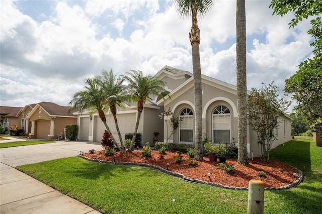 29542 Forest Glen Dr, Wesley Chapel, FL 33543 - mediterranean / spanish house featuring concrete driveway, an attached garage, a front yard, and stucco siding