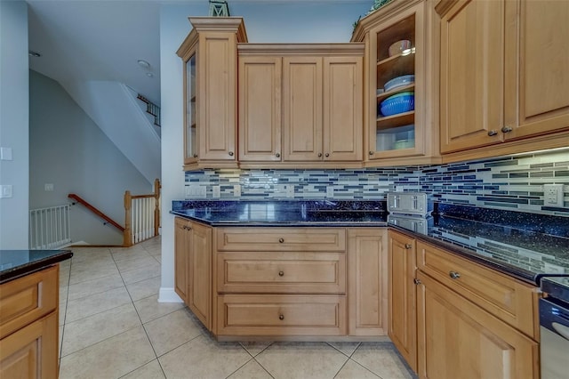620 Bayway Blvd Unit 1, Clearwater, FL 33767 - kitchen featuring dark stone counters, light tile patterned floors, and backsplash