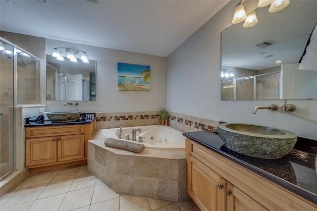 620 Bayway Blvd Unit 1, Clearwater, FL 33767 - bathroom with a tub with jets, tile patterned floors, two vanities, a sink, and a stall shower