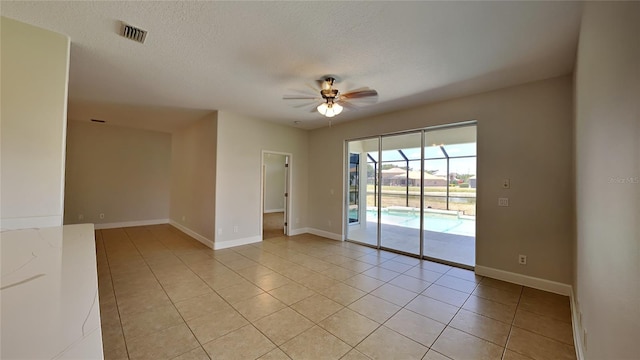 spare room with visible vents, baseboards, ceiling fan, a textured ceiling, and light tile patterned floors