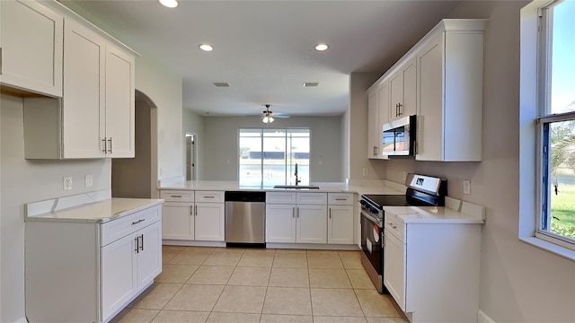kitchen with white cabinets, ceiling fan, a sink, stainless steel appliances, and recessed lighting