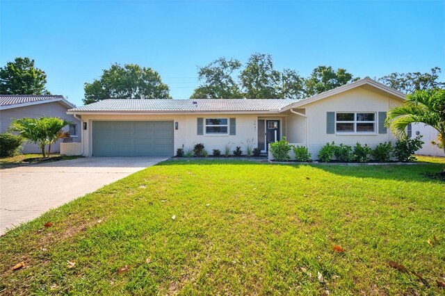 5647 110th Way, Seminole, FL 33772 - ranch-style house featuring a garage, driveway, a front lawn, metal roof, and brick siding