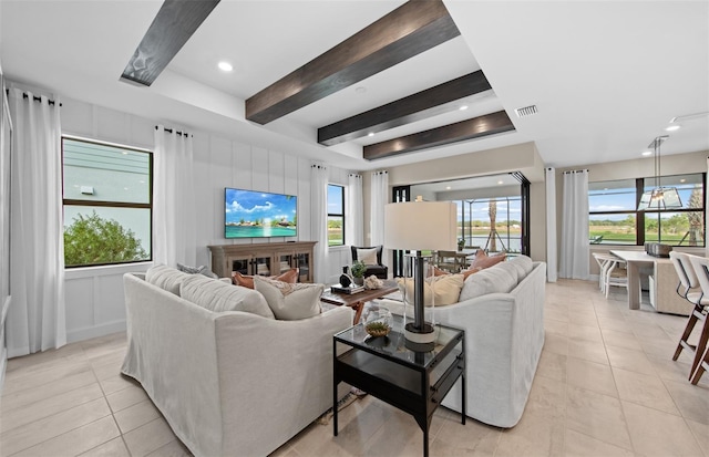 living room featuring beam ceiling, visible vents, and light tile patterned floors