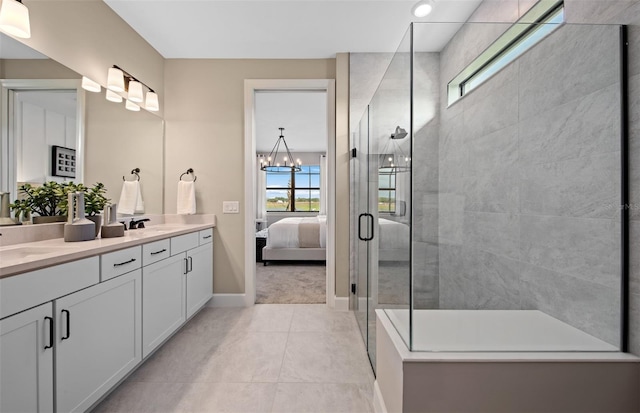 ensuite bathroom with double vanity, baseboards, tile patterned floors, connected bathroom, and tiled shower