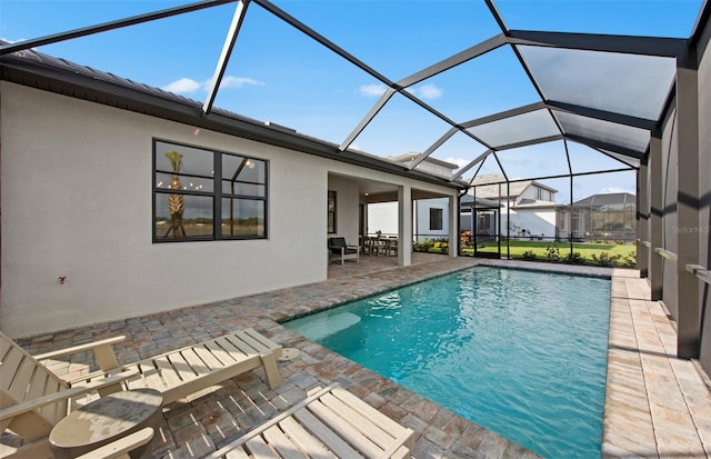 outdoor pool featuring glass enclosure and a patio area