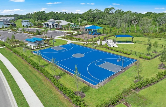 view of basketball court with fence, community basketball court, and a lawn