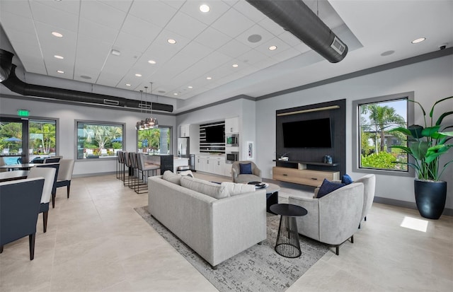 living room featuring baseboards, a tray ceiling, and recessed lighting