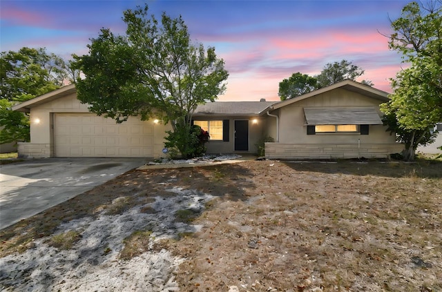 ranch-style home featuring a garage, stucco siding, and driveway
