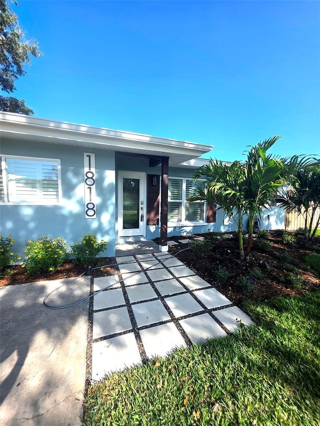 doorway to property featuring stucco siding
