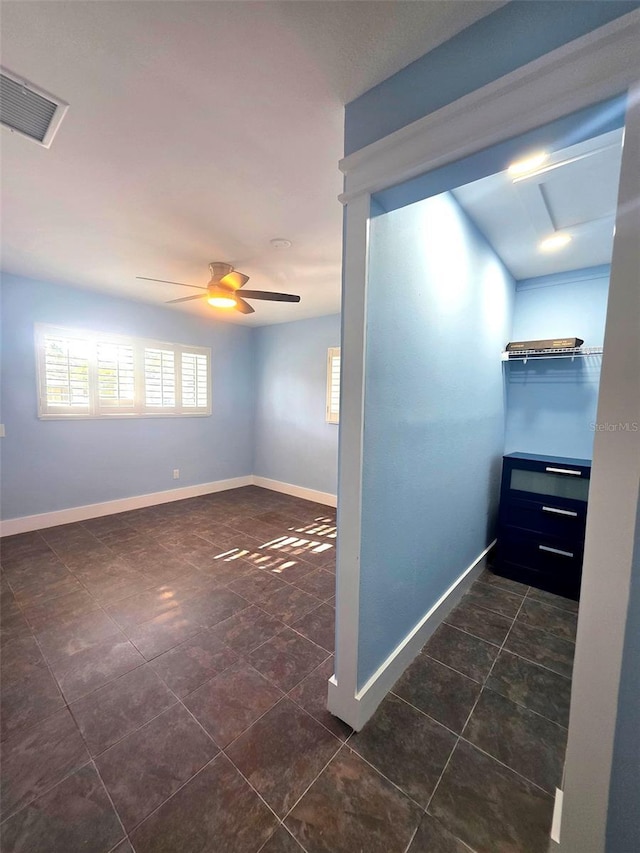 interior space with dark tile patterned floors, baseboards, and visible vents