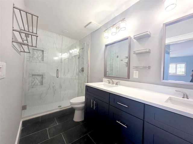 full bath with a sink, double vanity, toilet, and a marble finish shower