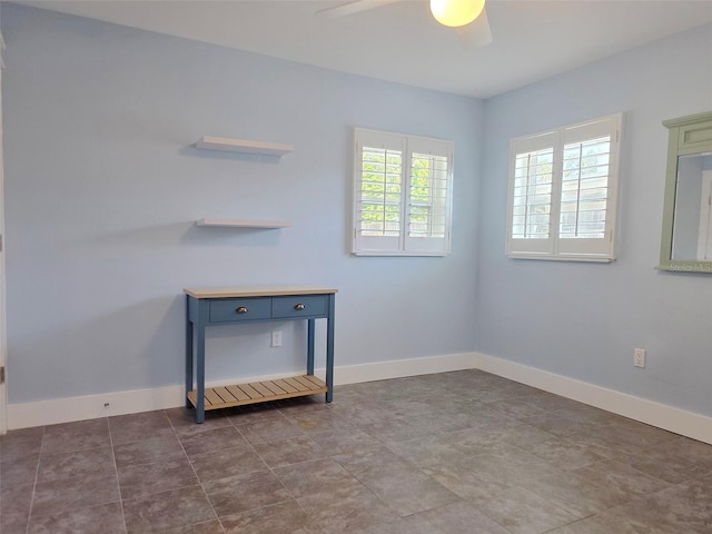 spare room featuring baseboards and a ceiling fan