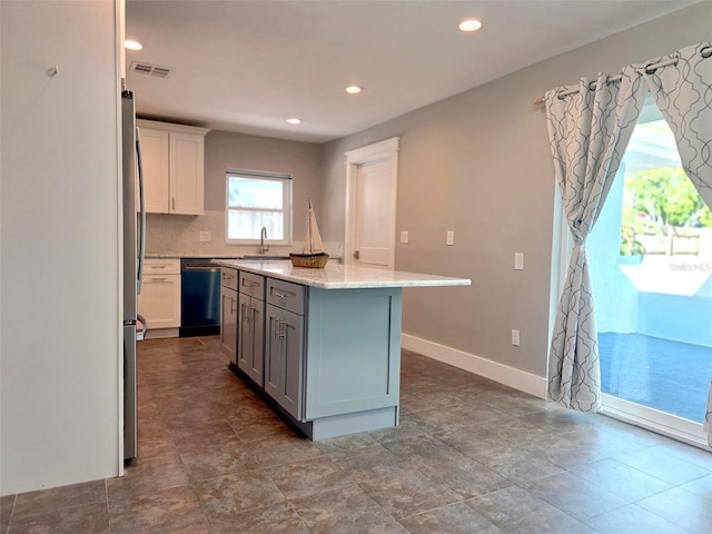 kitchen with dishwashing machine, visible vents, recessed lighting, a center island, and baseboards