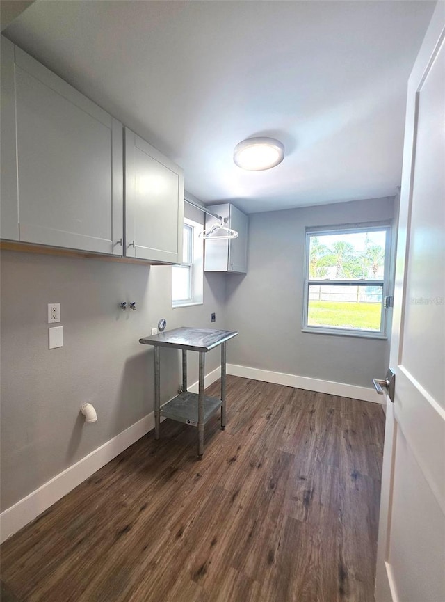 washroom featuring electric dryer hookup, cabinet space, washer hookup, a wealth of natural light, and dark wood-style floors