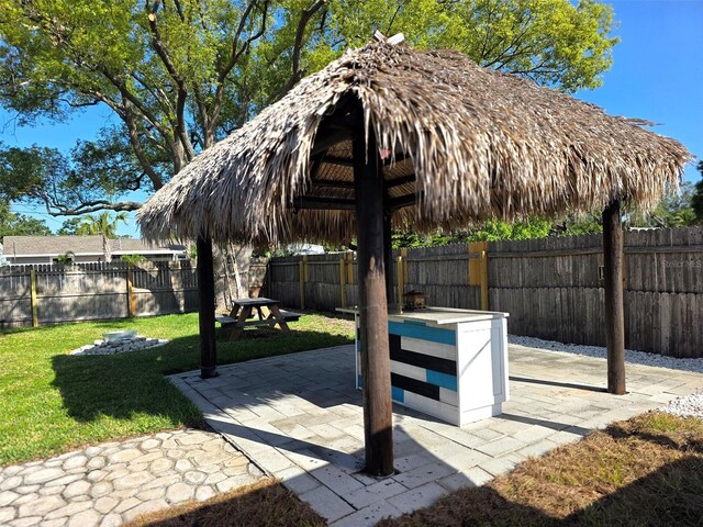 view of home's community with a fenced backyard, a gazebo, a patio, and a lawn