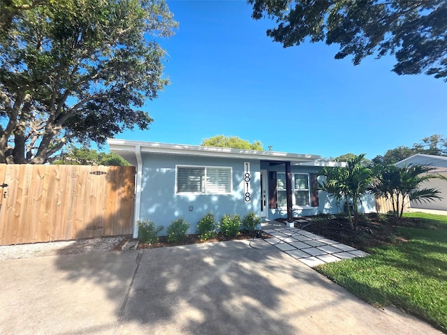 bungalow-style house with fence and stucco siding