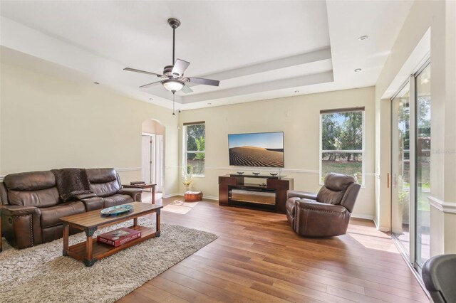 20254 Ravens End Dr, Tampa, FL 33647 - living area with plenty of natural light, arched walkways, a raised ceiling, and hardwood / wood-style floors