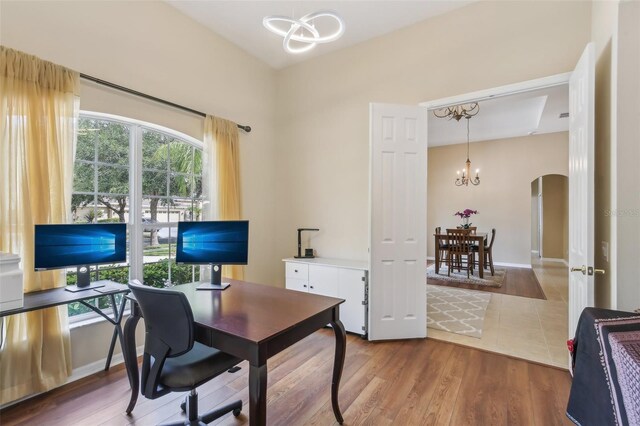 20254 Ravens End Dr, Tampa, FL 33647 - home office with arched walkways, wood finished floors, and a chandelier