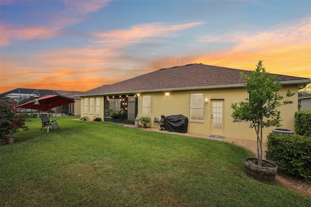 20254 Ravens End Dr, Tampa, FL 33647 - rear view of house with a yard, a shingled roof, and stucco siding