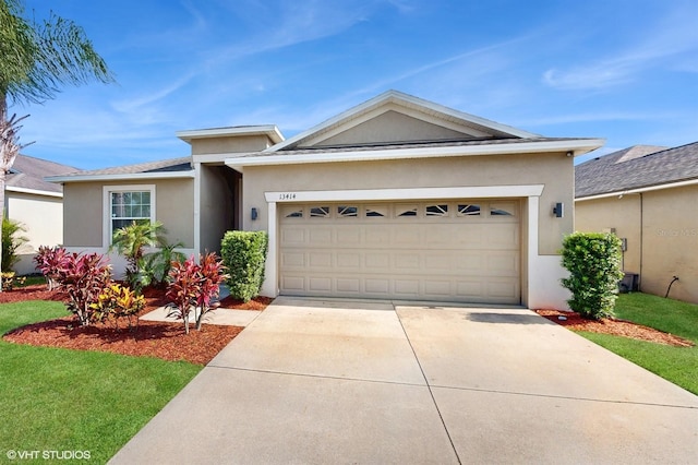 view of front facade with a garage, stucco siding, and driveway