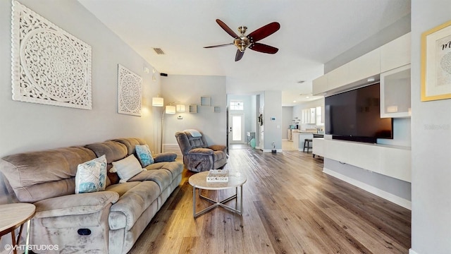 living room featuring visible vents, baseboards, ceiling fan, and wood finished floors